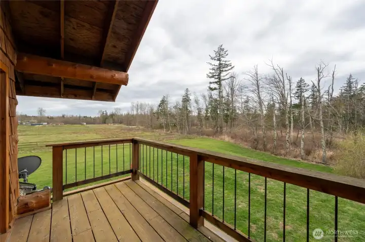 The primary suite balcony offers a beautiful view with stairs leading down to the wrap around deck