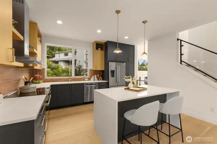 Seamless connection from living to the chef’s kitchen. The central island offers seating, prep space, and a natural hub for guests.