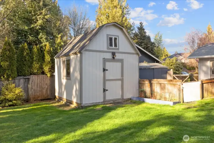 A storage shed provides practical space for tools and gardening needs.