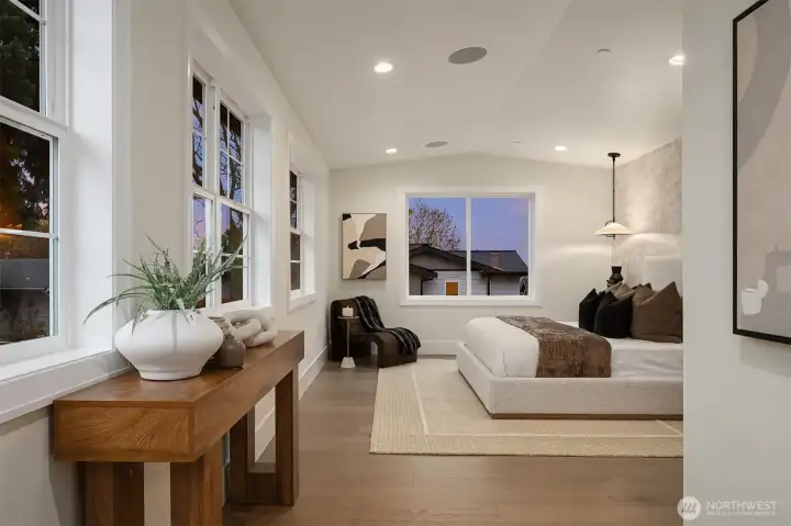 Spacious primary bedroom featuring generous proportions, speakers, and abundant windows that fill the room with natural light.