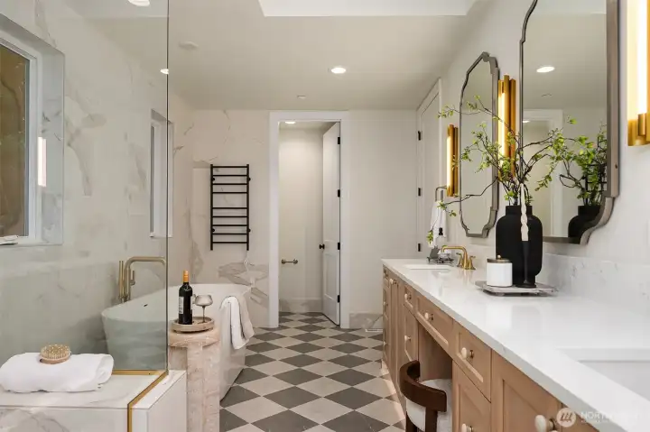 his angle highlights the thoughtful layout of the primary bathroom, featuring radiant heated floors, motion-sensor toe-kick lighting, dual vanity with designer lighting, and a glass-enclosed shower paired with a sculptural soaking tub.