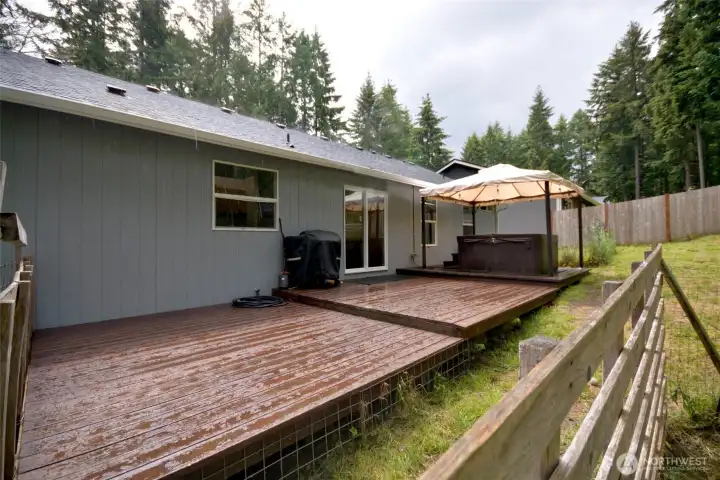 Enjoy relaxing and entertaining in the backyard with a huge deck ideal for summer gatherings. Unwind in the hot tub spa tucked beneath the covered gazebo, while two storage sheds provide extra room for tools and outdoor equipment. The partially fenced yard also features a cozy firepit area where you can enjoy peaceful evenings under the vibrant stars roasting s’mores. Enjoy relaxing and entertaining in the backyard with a huge deck ideal for summer gatherings. Unwind in the hot tub spa tucked beneath the covered gazebo, while two storage sheds provide extra room for tools and outdoor equipment. The partially fenced yard also features a cozy firepit area where you can enjoy peaceful evenings under the vibrant stars roasting s’mores.