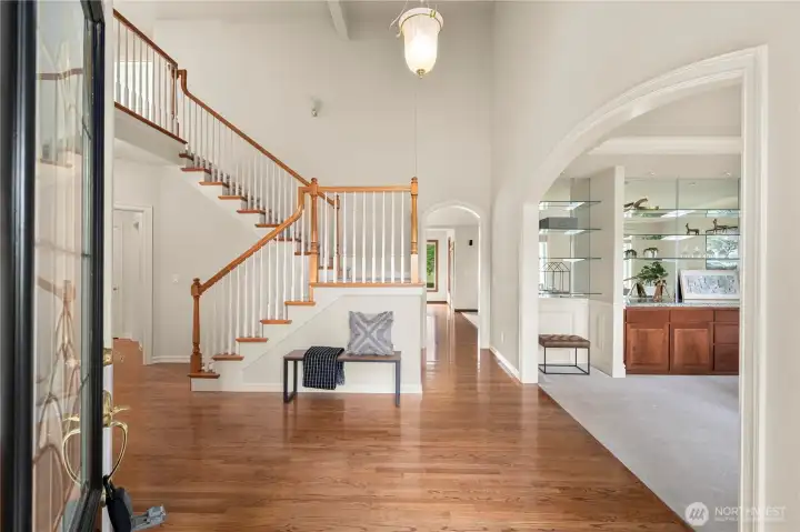 Step into a spacious entry featuring soaring vaulted ceilings and circular floor plan on the main.