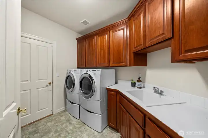 The spacious utility room with additional storage is located just left of the entry, leading toward the primary bedroom.