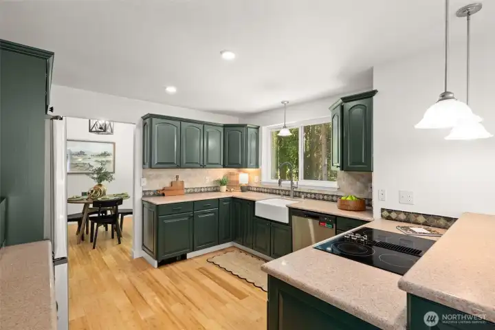 Updated kitchen with freshly painted cabinetry, farmhouse sink and granite countertops