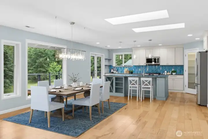 Inside, wall of windows frames peaceful views of the surrounding greenery, creating a seamless connection to the outdoors. The light-filled main level features beautiful wood floors, an updated kitchen, skylights, and an open-concept design perfect for everyday entertaining Inside, wall of windows frames peaceful views of the surrounding greenery, creating a seamless connection to the outdoors. The light-filled main level features beautiful wood floors, an updated kitchen, skylights, and an open-concept design perfect for everyday entertaining