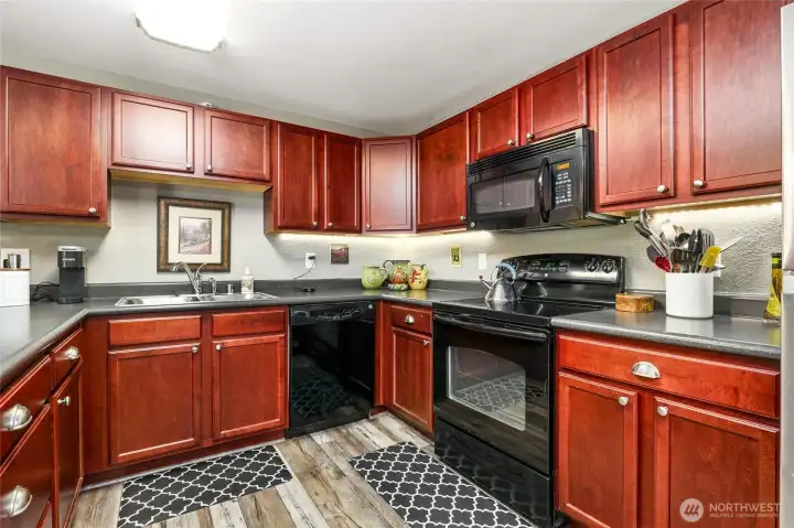 Rich Cherry wood cabinetry, hardwood floors and all black appliances Rich Cherry wood cabinetry, hardwood floors and all black appliances