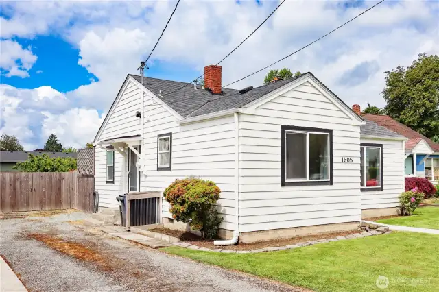 Gravel driveway runs alongside the home with side entrance leading to the laundry room.