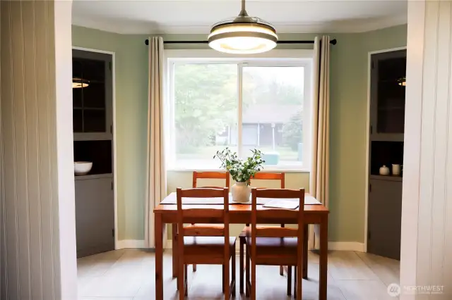 Charming dining room with built-in cupboards and a large window overlooking the front street.