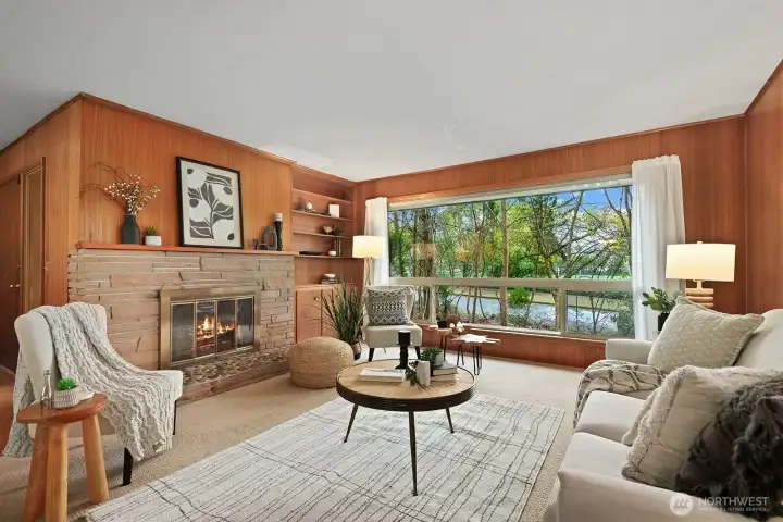 Gracious and open living room with a wood burning fireplace and large picture window.