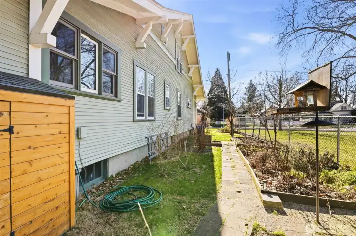 Side yard with storage shed, raised beds and bird feeder