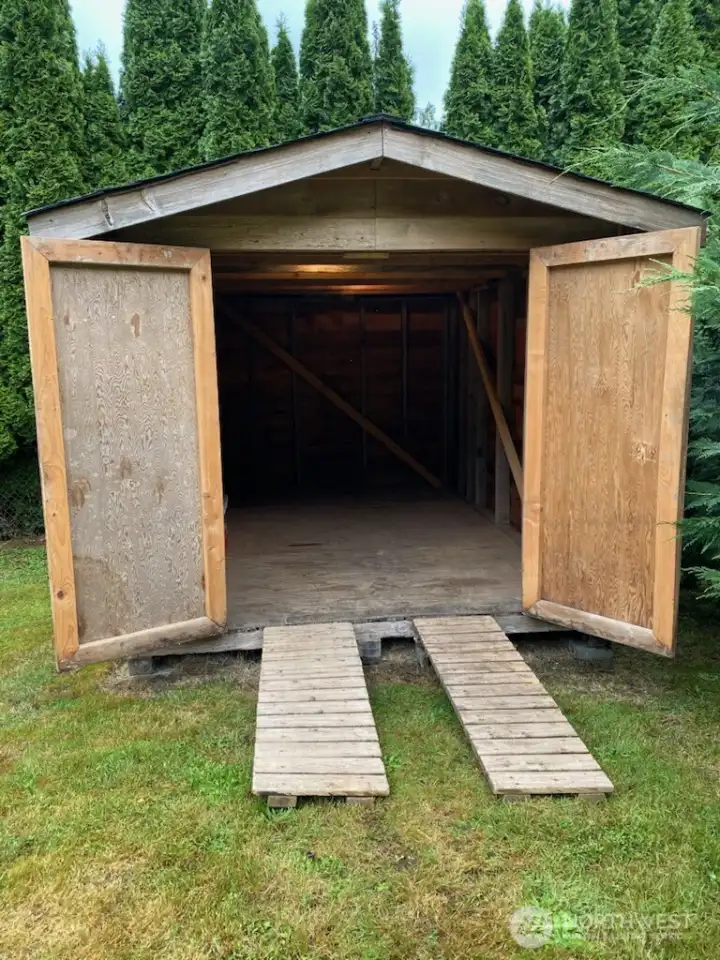 Second outbuilding measures approximately 7'4" wide by 11" long; approximately 81 square feet. Great option for reducing potential offsite storage costs. Has 2 ramps to get the riding lawnmower in the shed, etc. This outbuilding has power.