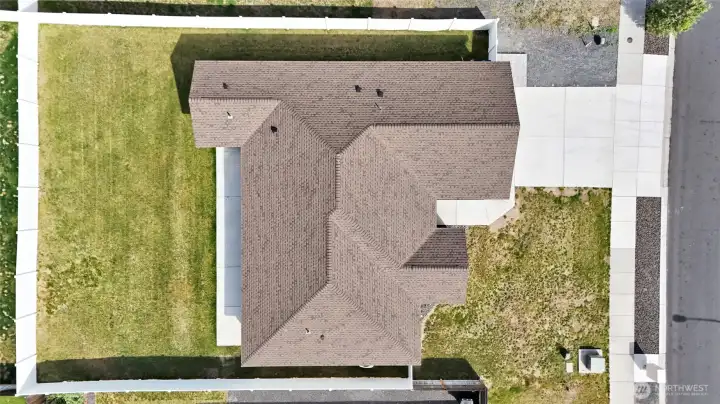 Overhead aerial showing roofline, fenced backyard, and lot configuration