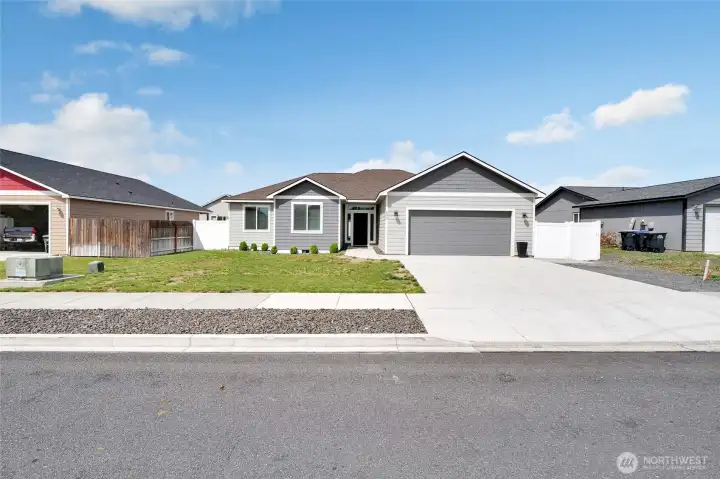 Front exterior view of single-level home with attached garage and landscaped frontage