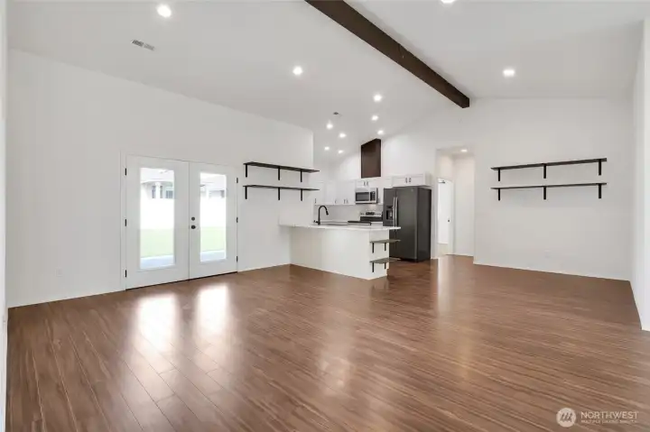 Open living room and kitchen layout with vaulted ceiling beam detail