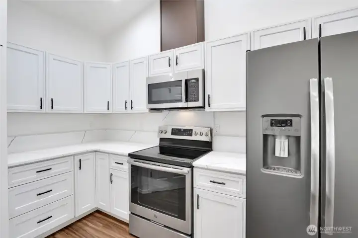 Kitchen featuring stainless steel appliances, upper cabinetry, and counter space