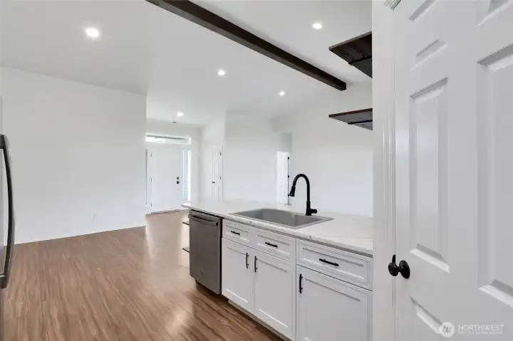 Kitchen island with sink, storage, and open sightlines to living area