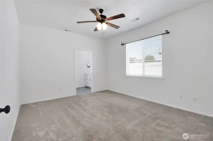 Primary bedroom alternate angle with window and bathroom access