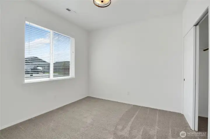 Additional bedroom with carpet flooring and neighborhood-facing window