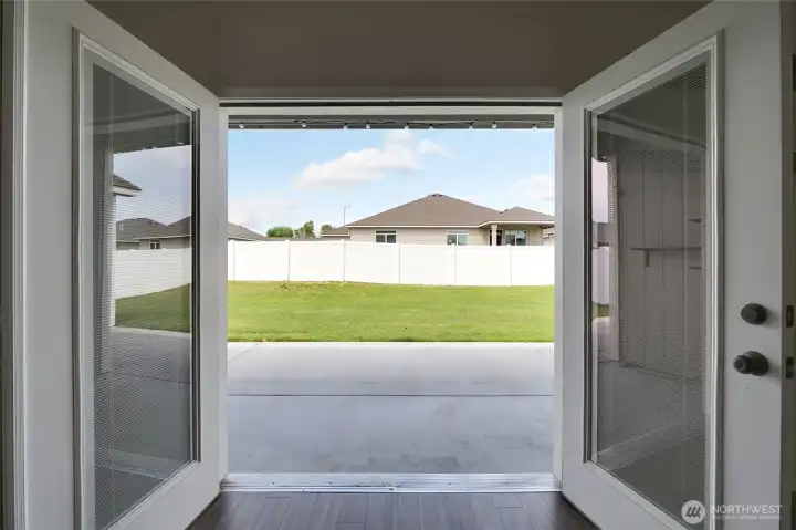 Covered patio access with view of fully fenced backyard