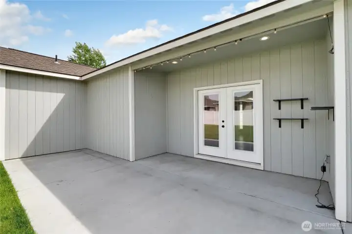 Covered patio area with outdoor seating potential and backyard access