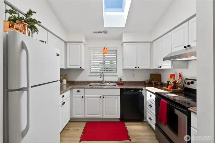 Thiis  is a kitchen you'll never find dark! Natural light pours in through the window and overhead skylight. A pantry offers ample storage for all your kitchen essentials.