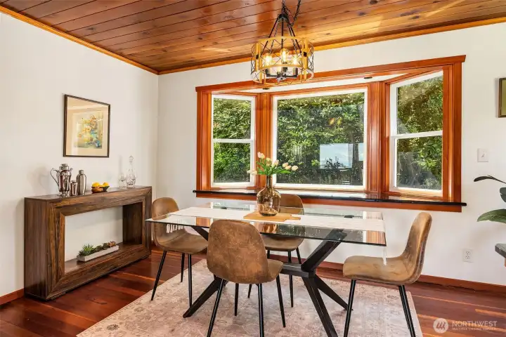 The intimate dining area is crowned by the original cedar-clad ceiling, while a sunlit bay window is finished with matching black granite, echoing the kitchen countertops with a subtle, polished continuity The intimate dining area is crowned by the original cedar-clad ceiling, while a sunlit bay window is finished with matching black granite, echoing the kitchen countertops with a subtle, polished continuity