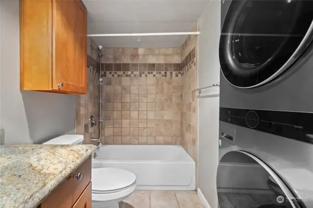 Tile flooring and tub surround with granite countertop.