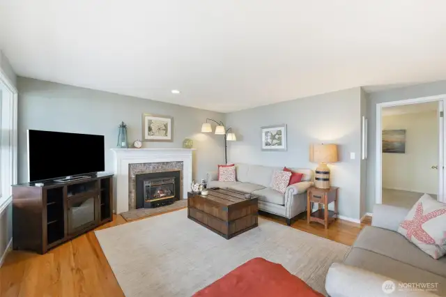 The living room features hardwood floors and a cozy fireplace.