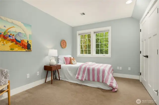 The third bedroom upstairs offers peaceful treetop views and plenty of space.