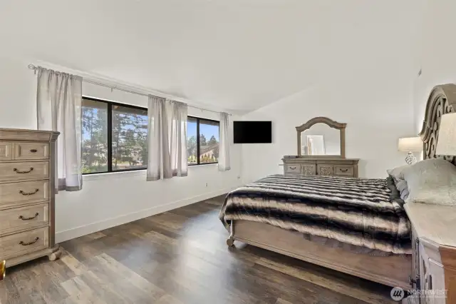 Primary bedroom with large windows that overlook the huge backyard.