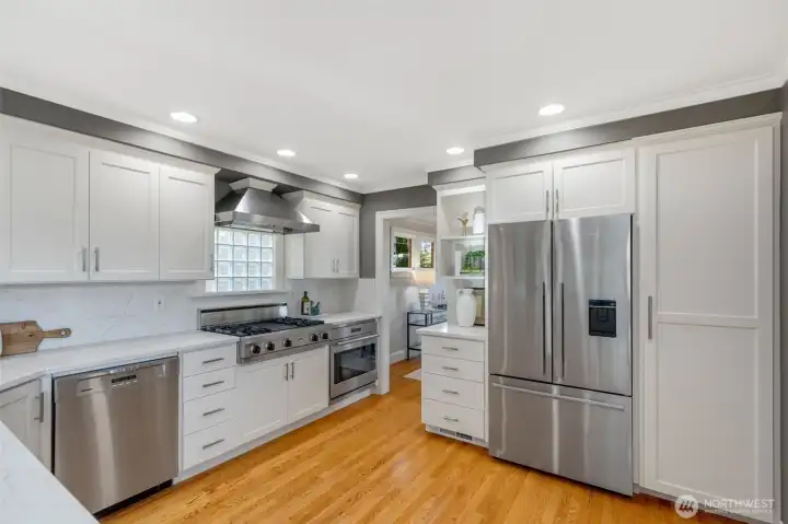 The kitchen has been fully remodeled with top of the line stainless appliances and quartz countertops.  A large deep sink, and lots of counter and cabinet space make this kitchen super functional as well as beautiful. Notice the large pantry cabinet to the right of the fridge, there is another set to the right of that as well!