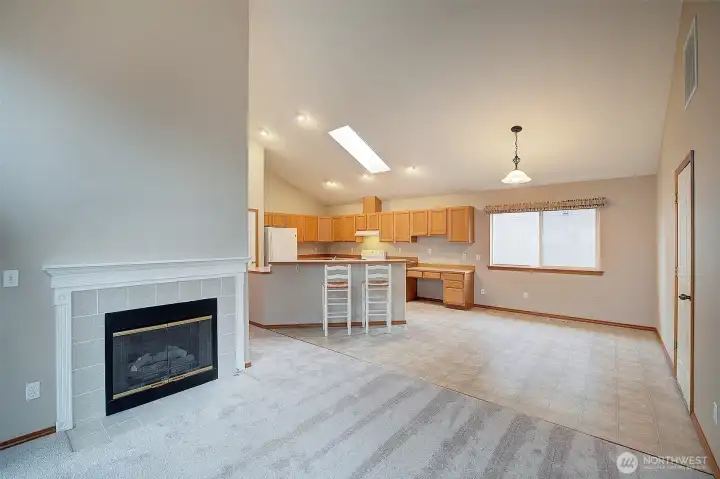 From family room, view back into the open and bright kitchen and kitchen dining area. 2 car Garage is on the right.