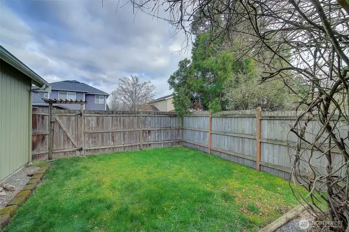 Back lawn area off of the Patio with gate to the alley and garage.
