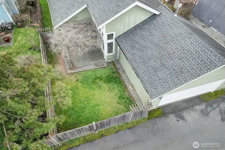 Close up of the patio and fenced yard area with Wisteria covered pergola.