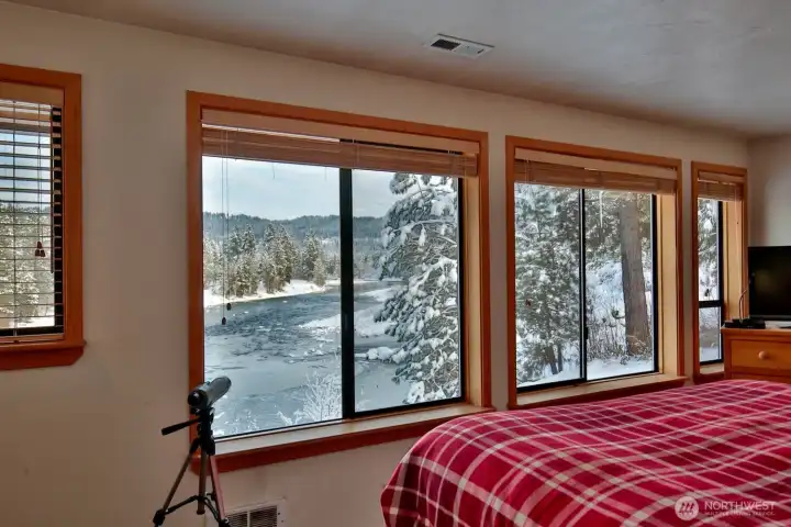 Wake up to sweeping river views framed by large windows in the comfort of the primary suite.