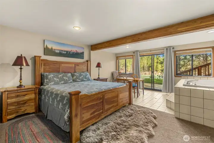 Expansive bedroom with ensuite soaking tub, natural light, and access to the outdoors for a true retreat experience