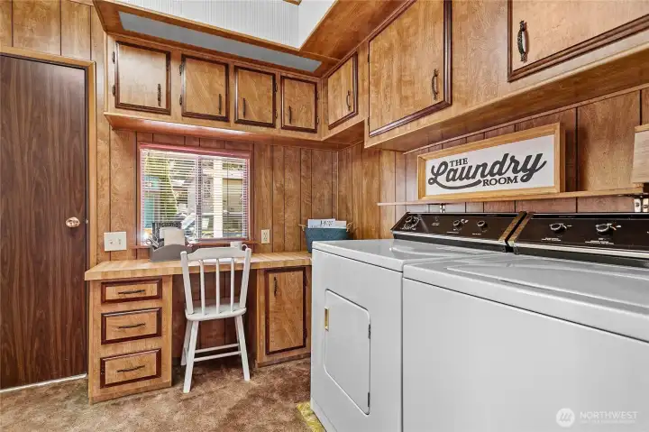 Nice sized laundry room with built in desk and large closet for storage