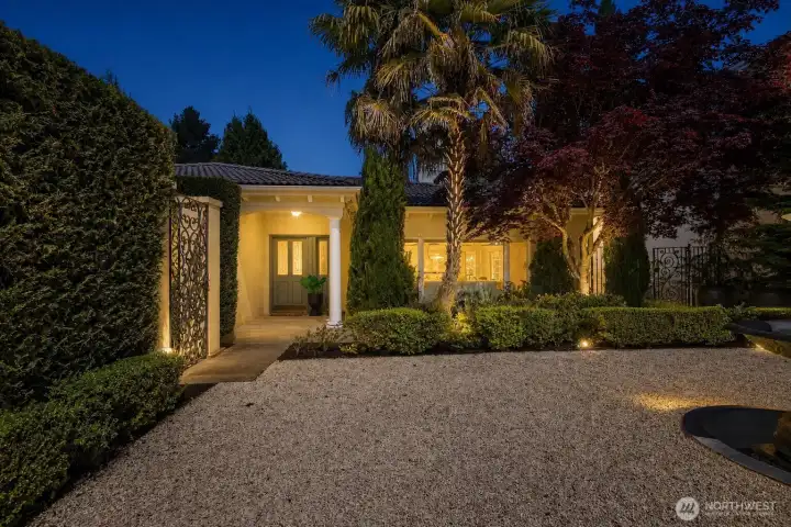 Twilight entry framed by mature landscaping and a welcoming approach.