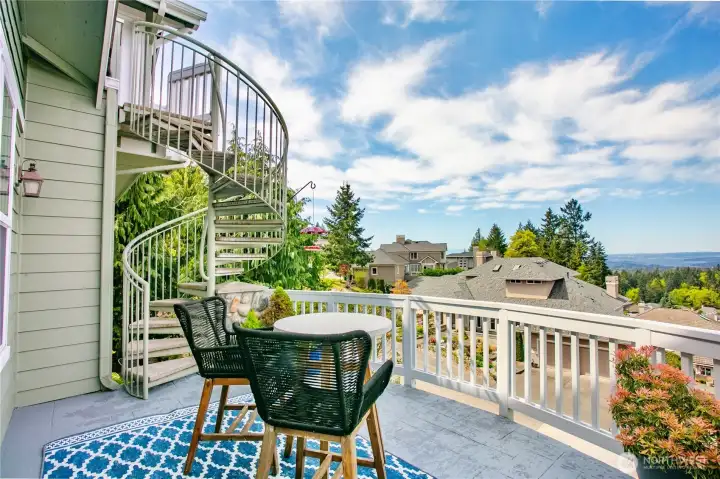 Deck off the family room with views of Downtown Bellevue, Lake Washington, and the Cascades. Spiral staircase up to primary suite