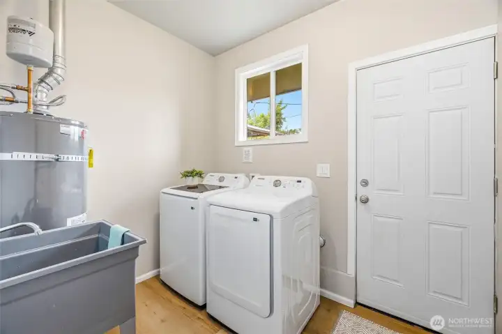 Laundry mud room with sink and door to the back yard.
