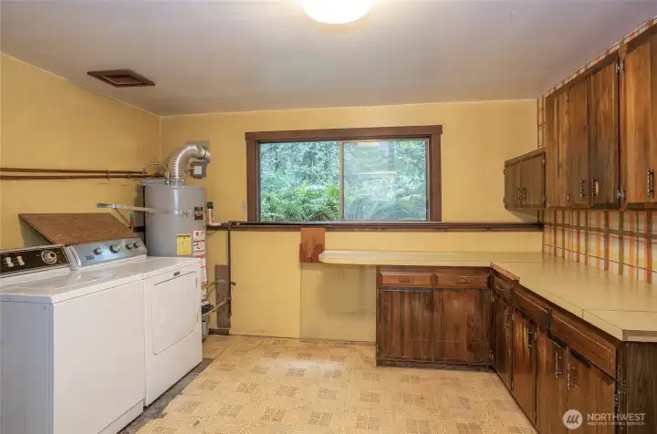 Lower-level utility room featuring counter space and built-in cabinetry for added storage and functionality.