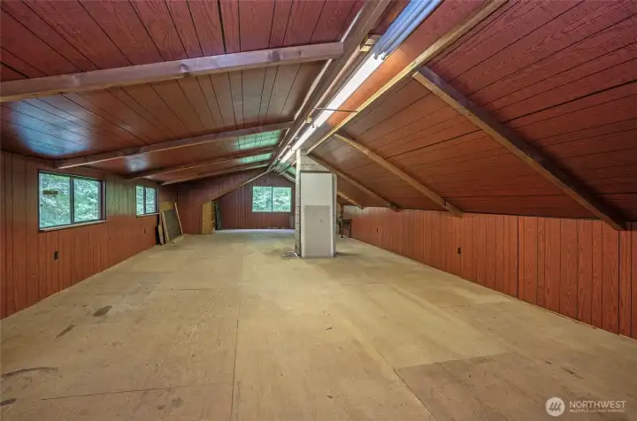 Huge partially finished attic expands the possibilities even further, complete with lighting and subflooring—perfect for organized storage today or future finishing potential.