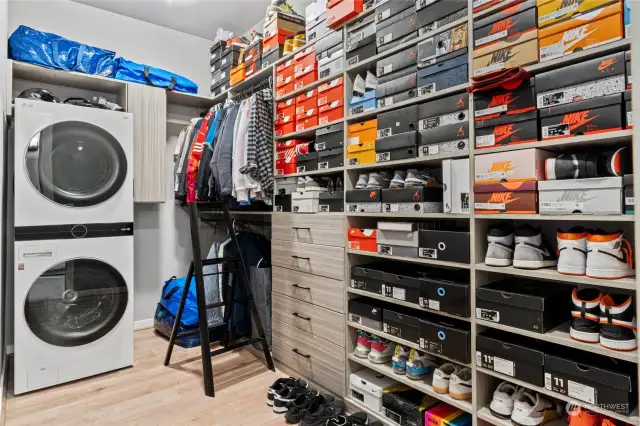 This is a dream primary suite walk in closet! Complete custom organizer with room for all your shoes! There is even a full size Stacked Washer & Dryer in this primary suite closet!