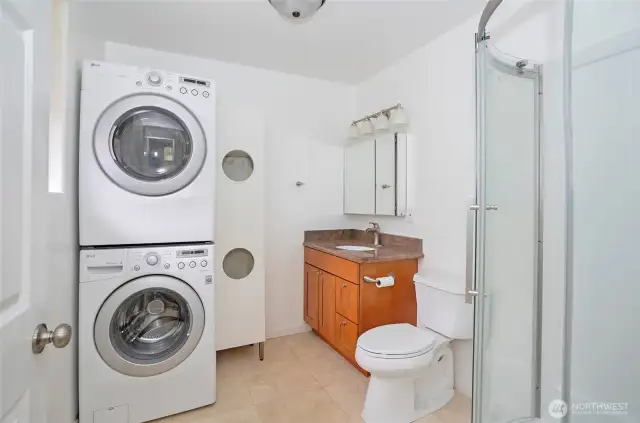 The primary bath features a conveniently located washer and dryer for added ease and functionality.