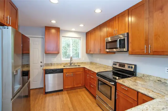 The kitchen boasts granite countertops, soft-close cabinets and drawers, and sleek stainless steel appliances—simply stunning!