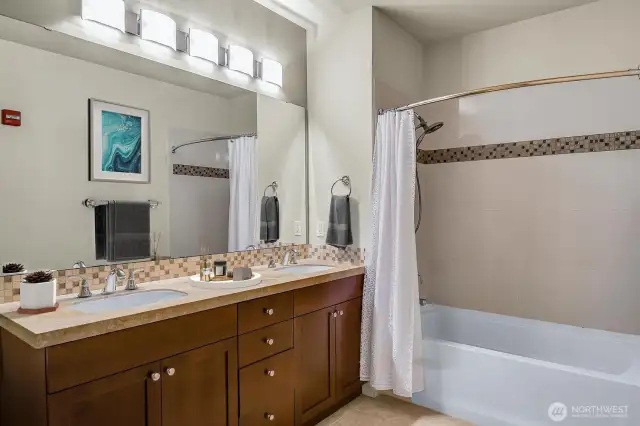 Full en-suite primary bath featuring dual sinks & designer tile work.