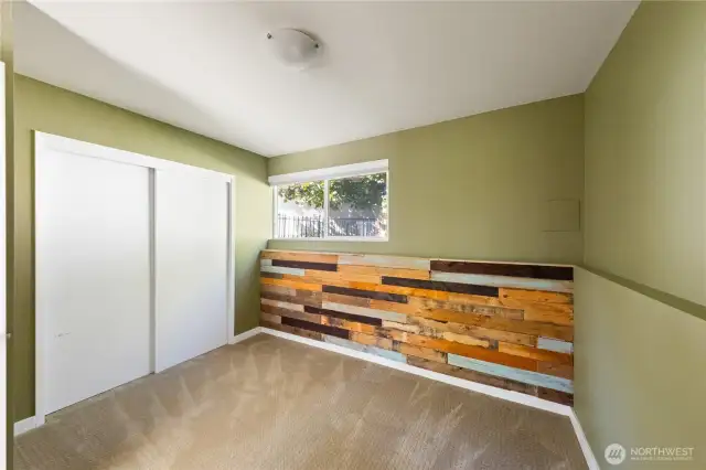 Large lower level bedroom with wood detailing accent wall.