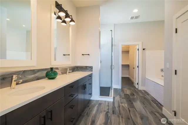 Luxurious en suite bathroom off the primary bedroom. Double sinks, tons of storage and custom shower and bathtub before you enter the huge walk in closet. Custom closet system in place for you!