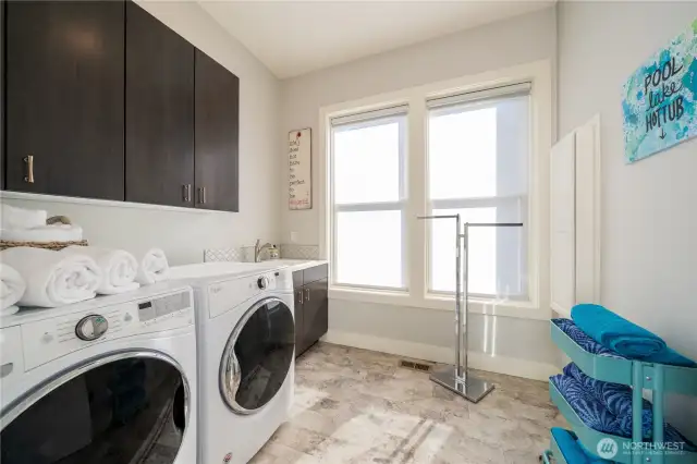 Large laundry room with sink and cabinets and room for towel storage and drying. This room is right off the garage to drop all the wet things and keep everything you need on the main level of the home.